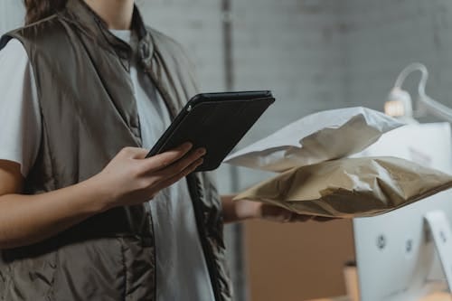 An individual checking her food recall alert on their device while holding a recalled product